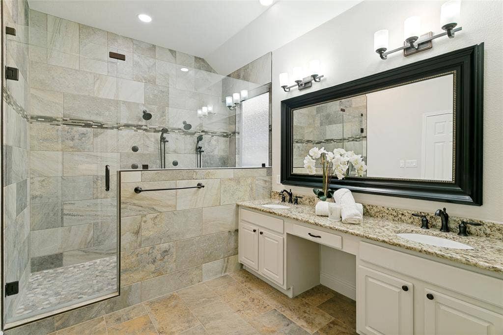 17 Adams Court, Mansfield, TX 76063 Walk-in shower with tile surround and pebble flooring, dual shower heads, body sprayers. dual vanities with integrated sinks, framed mirror, and tile flooring