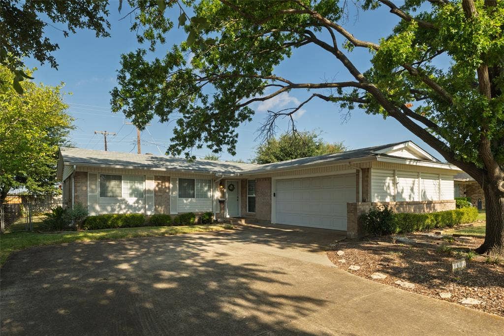 Ranch-style residence featuring a prominent two-car garage, brick and siding exterior, and a concrete driveway