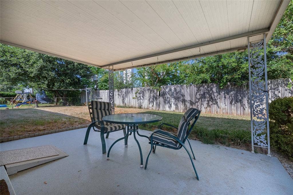 Covered patio area featuring a concrete surface and decorative metal posts