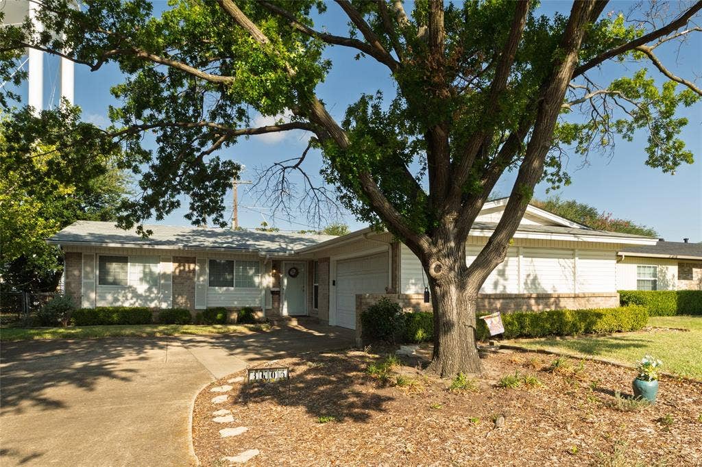 Single-story residence featuring a brick and siding exterior, an attached garage, and a concrete driveway