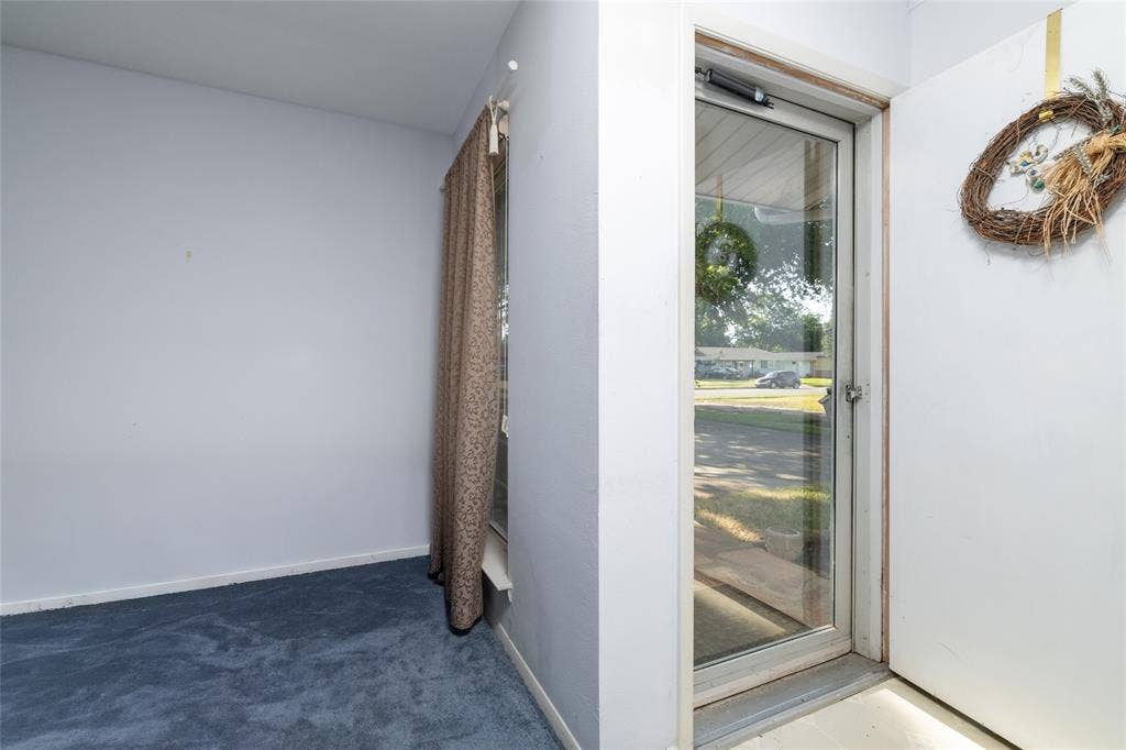 Entryway featuring a full-light storm door and blue carpeting