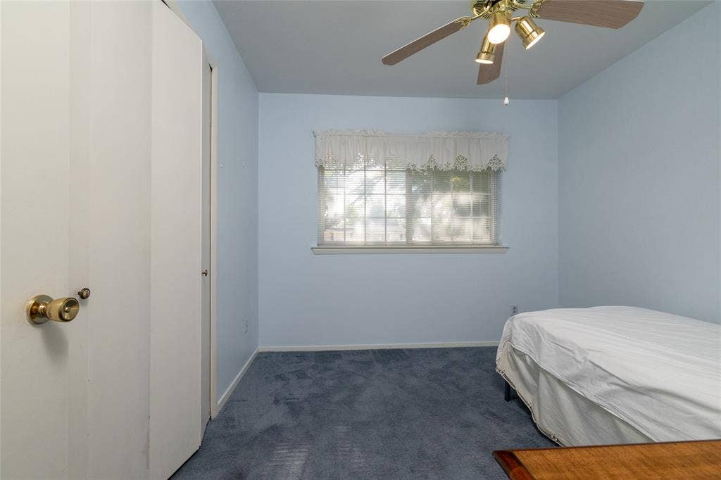 Wall-to-wall carpeting and a ceiling fan with integrated lighting