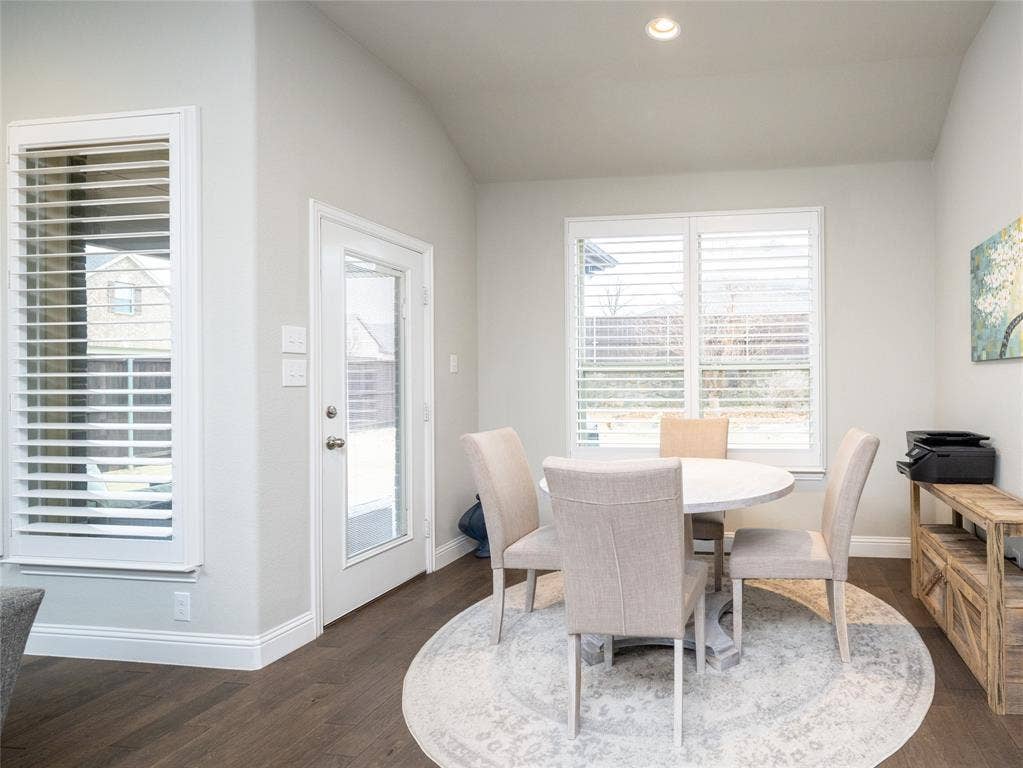 Recessed lighting, wood-finish flooring, white trim, and a glass-paneled exterior door