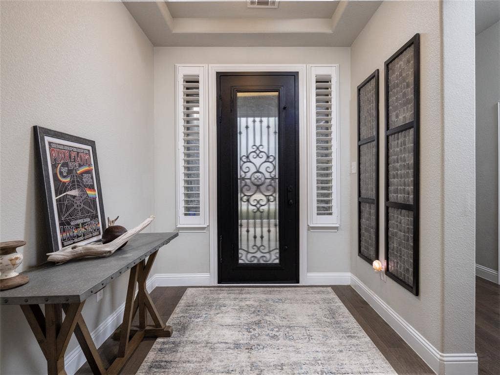 Ornate wrought iron front door with transom sidelights