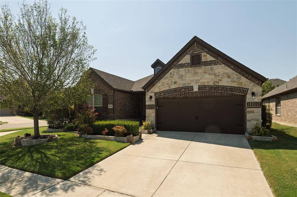 Brick and stone exterior with an arched garage opening