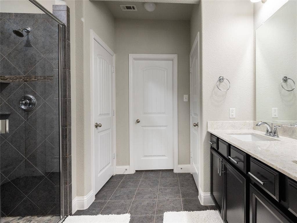 Walk-in shower with dark gray diagonal tile and a decorative accent band