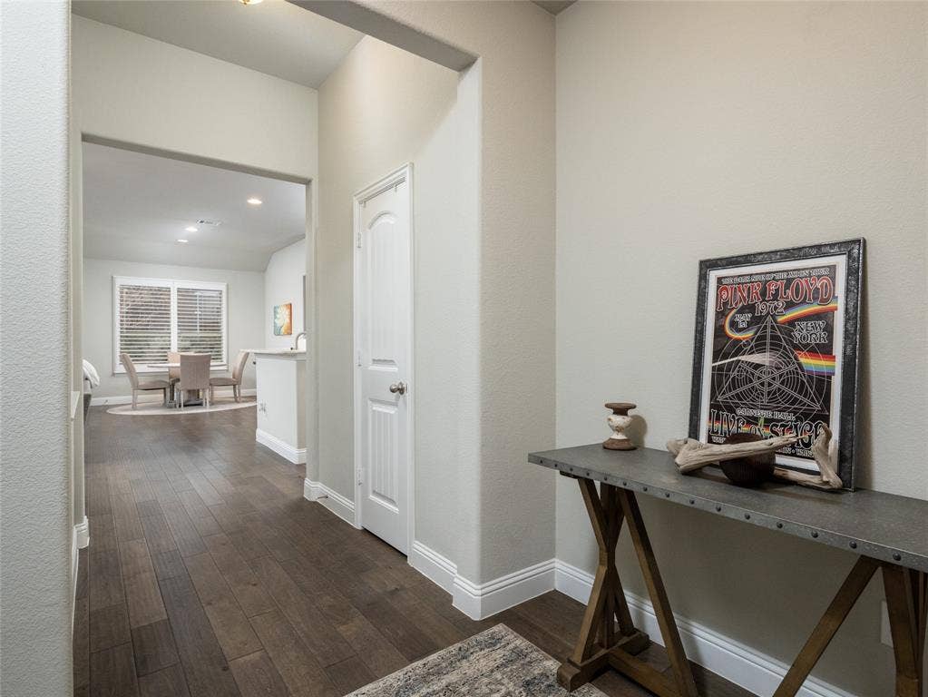 Wood-finish flooring throughout, complemented by crisp white baseboards and neutral wall tones
