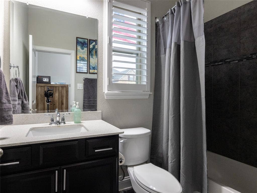 Dark wood-finish vanity with a light-toned countertop, undermount sink, and chrome fixtures