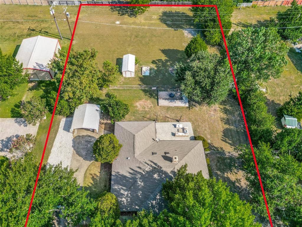 Expansive lot featuring a primary residence, detached carport, two storage sheds, and a large additional structure