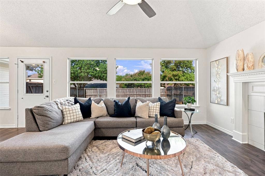 1110 Harvard Lane, Allen, TX 75002 Recessed ceiling fan, wood-finish flooring, white trim details, multiple windows, and a white fireplace with a decorative mantel