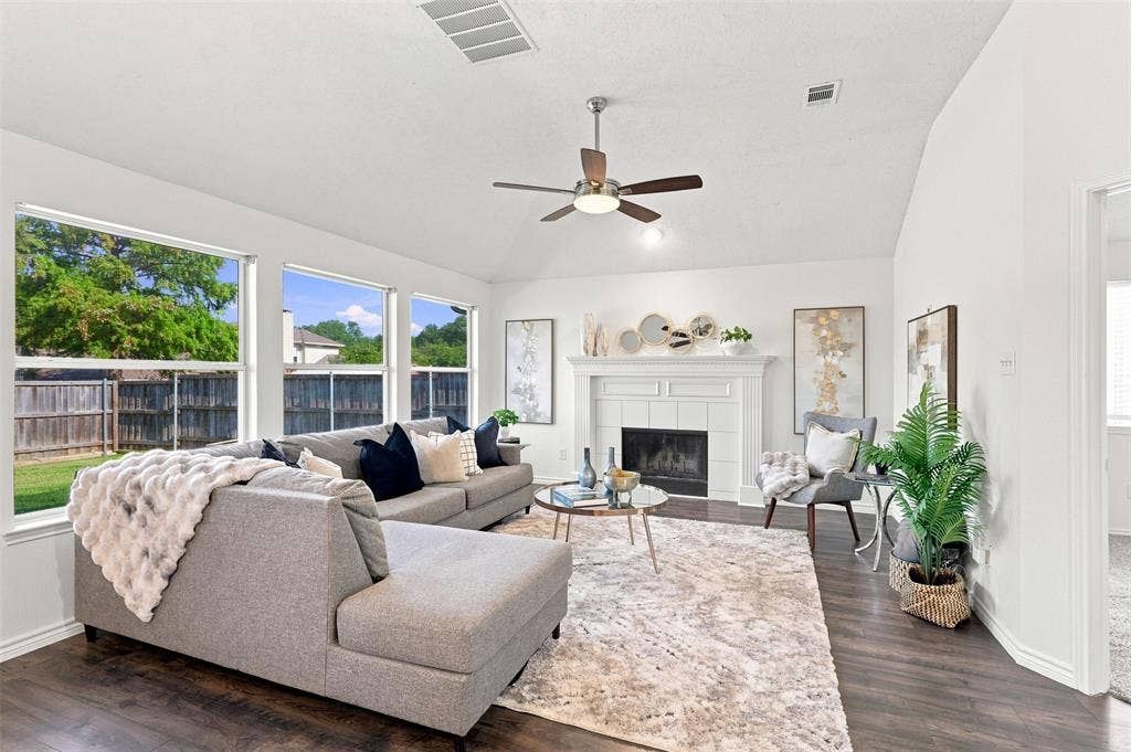 1110 Harvard Lane, Allen, TX 75002 Vaulted ceiling with a ceiling fan, fireplace with a white mantel, dark wood-finish flooring, and multiple windows