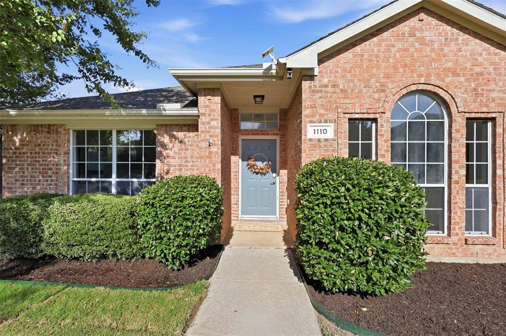 1110 Harvard Lane, Allen, TX 75002 Brick facade, arched window, front entry with transom, recessed entryway, and a concrete pathway