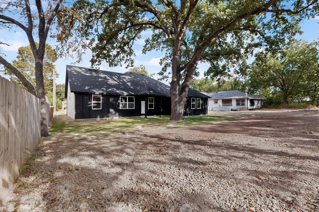 Black siding with white trim and a dark roof