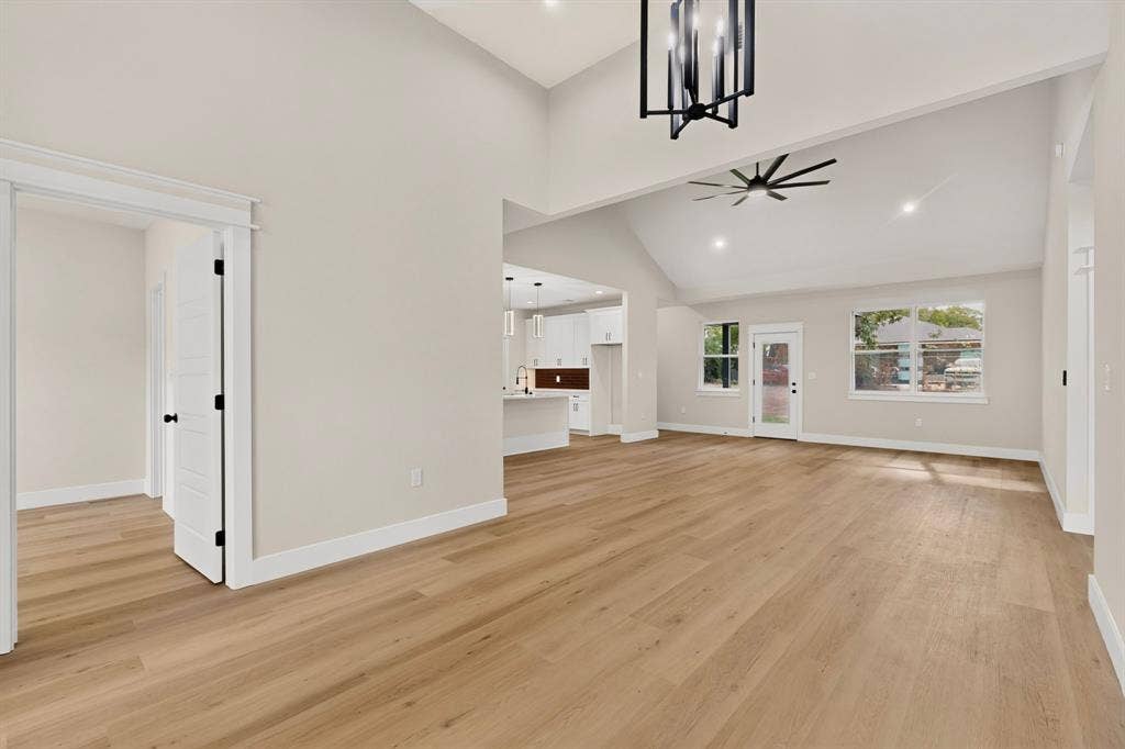 Vaulted ceilings, wood-finish flooring, recessed lighting, and a contemporary ceiling fan