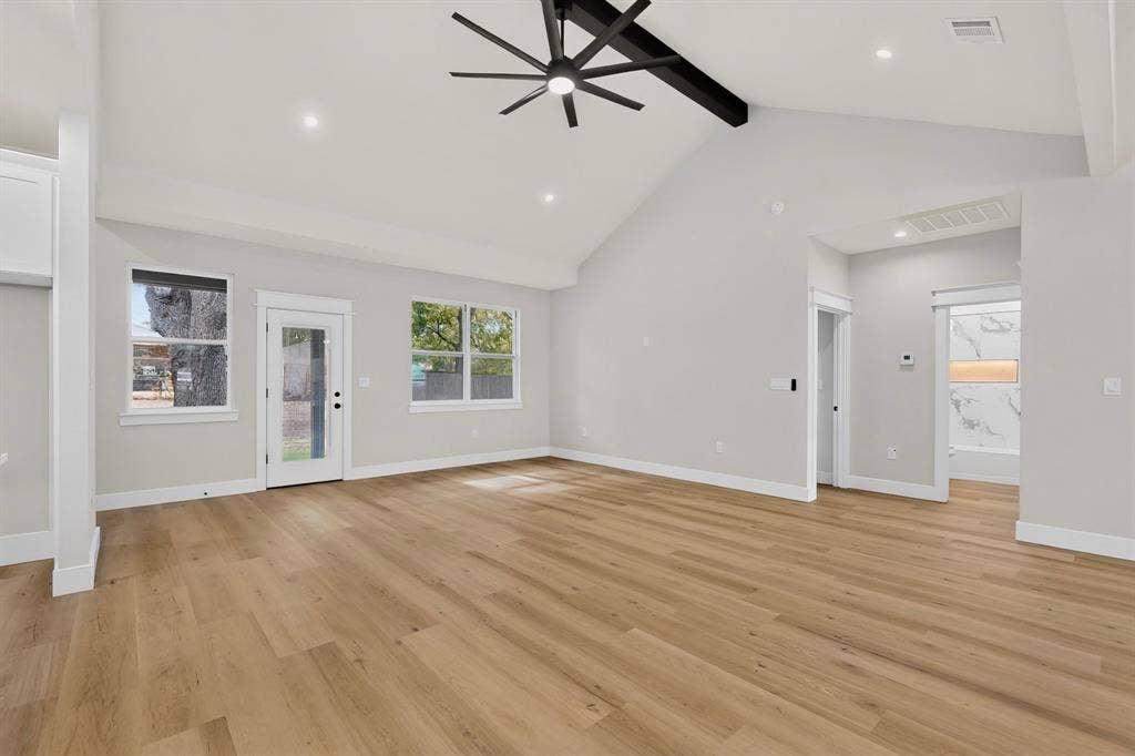 Vaulted ceilings with exposed beam, wood-finish flooring, recessed lighting, and a modern ceiling fan