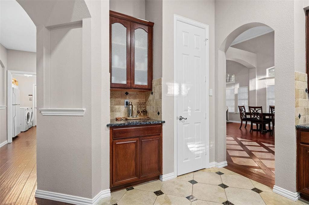 Butler's pantry with glass front cabinetry offers additional storage space.