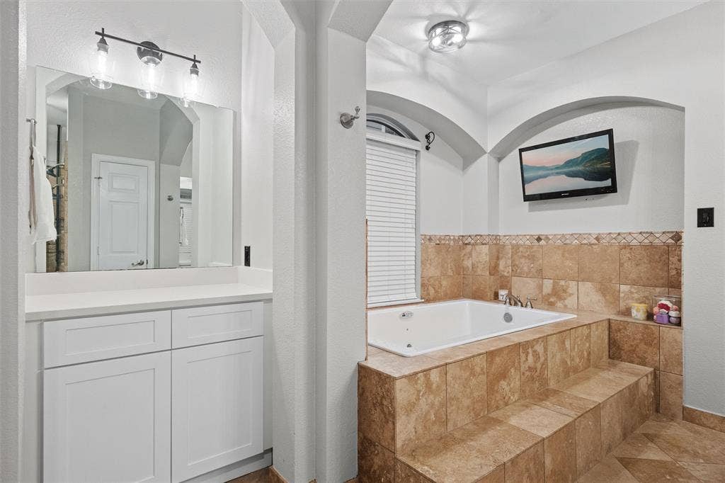 Spa-like primary bath with a jetted soaking tub and dedicated vanity area, creating a relaxing, functional retreat.
