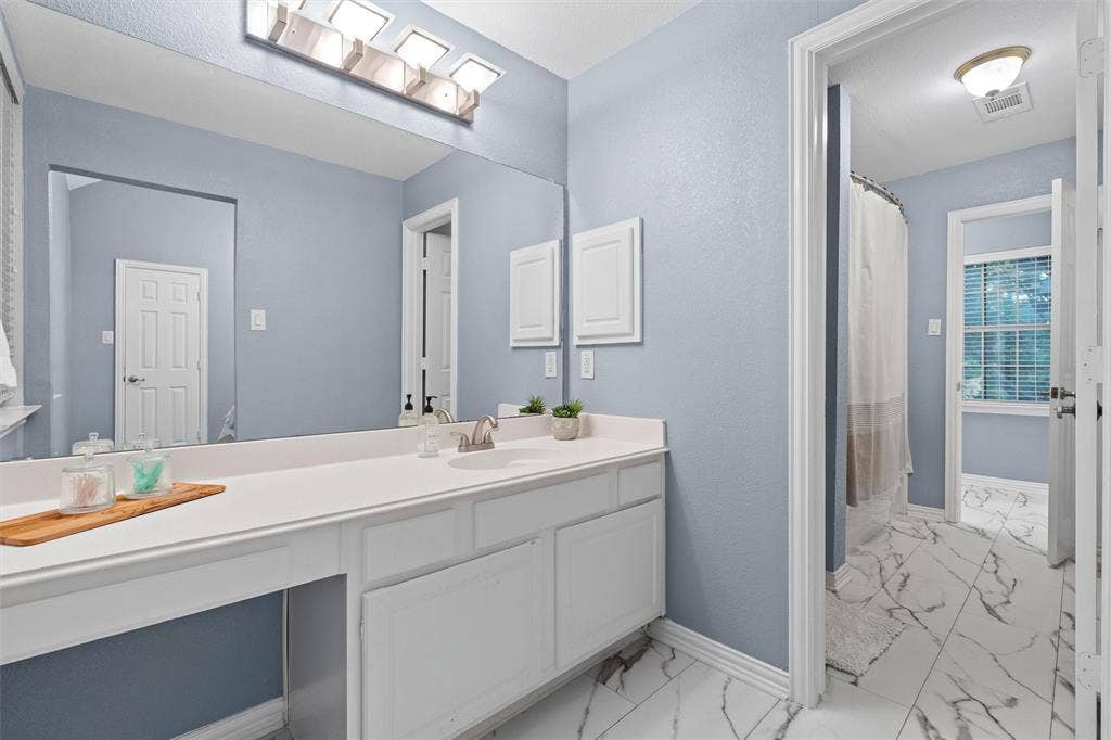 Upstairs jack and jill bath with new flooring installed July 2026.