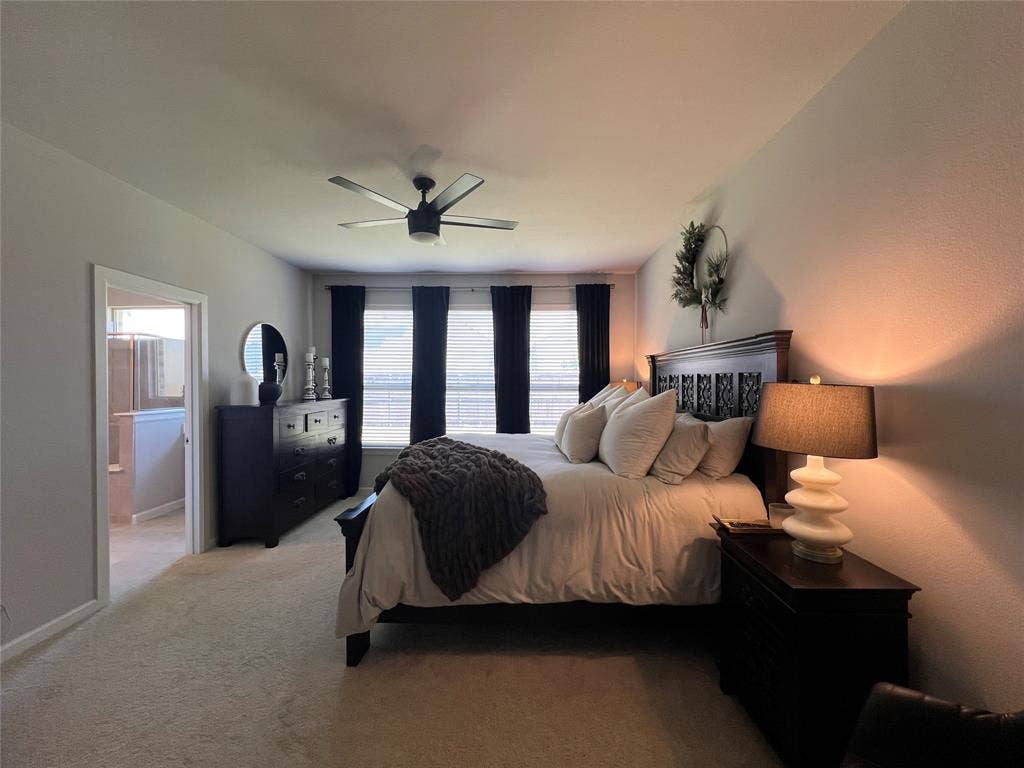 3210 Mattie Grey Lane, Melissa, TX 75454 Bedroom with light carpet, ceiling fan, and connected bathroom