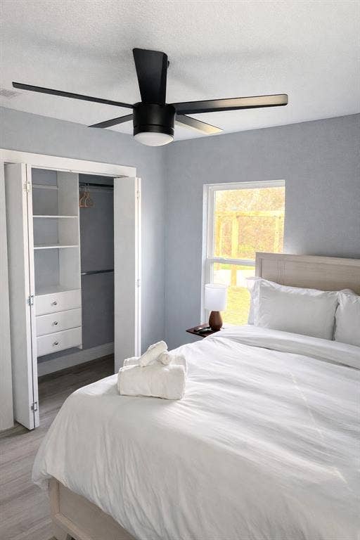 228 Harrison Lane, Hurst, TX 76053 Wood-finish flooring, built-in closet organization, contemporary ceiling fan, and a large window