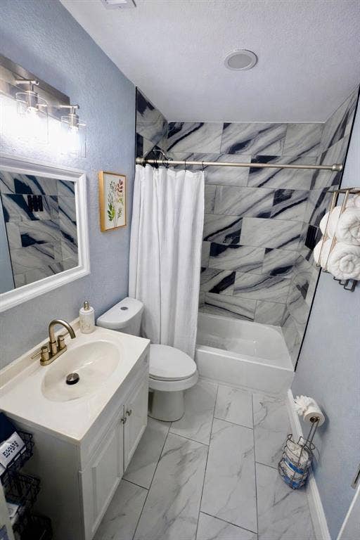228 Harrison Lane, Hurst, TX 76053 Vanity with integral sink, tub with tile surround, toilet, and tile flooring