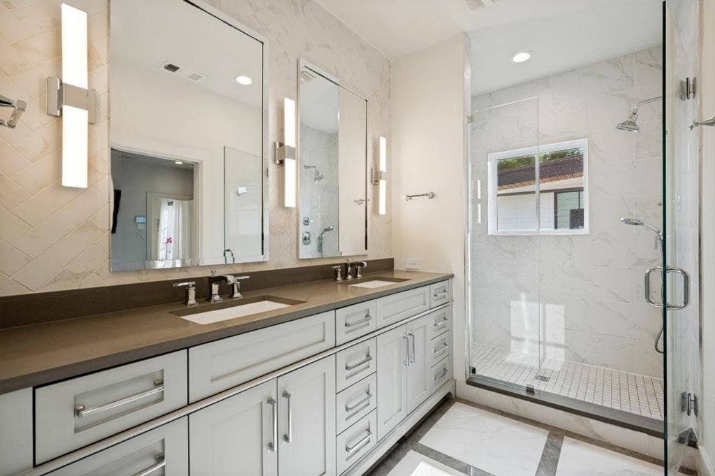 Dual vanity with undermount sinks, stone countertop, and contemporary lighting