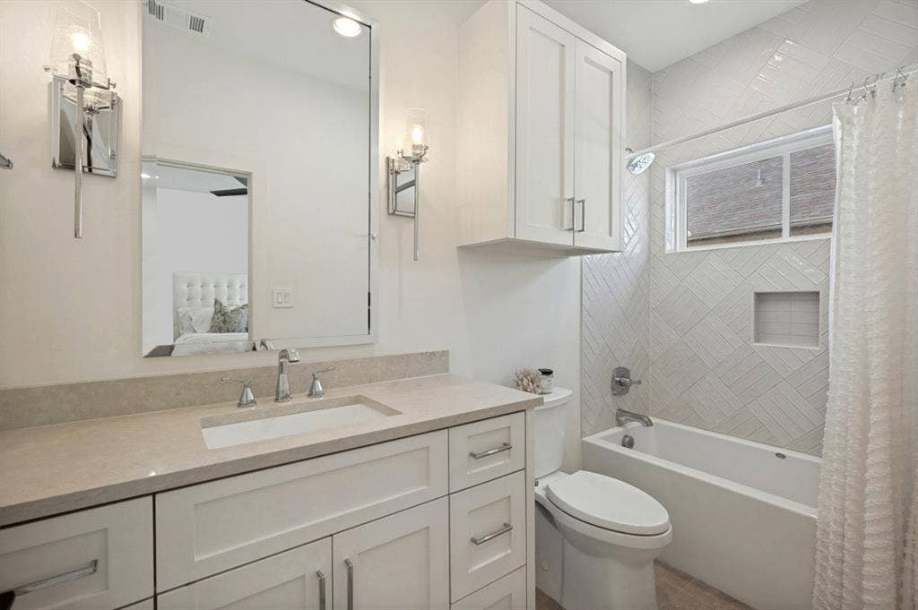 Vanity with an integrated sink, polished chrome faucet, and sconce lighting