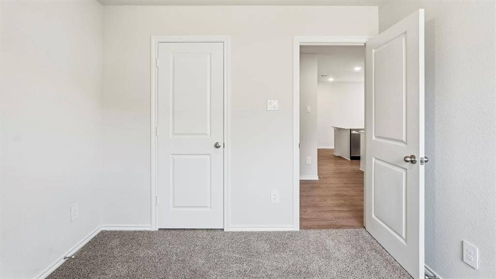 3327 Twilight Trail, Talty, TX 75126 Textured carpeting and white interior doors with satin nickel hardware