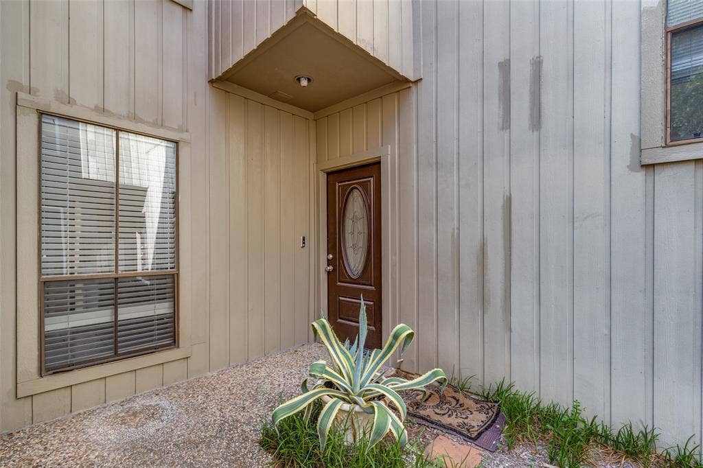 9400 Doliver Drive, #59, Houston, TX 77063 Recessed entry with overhead lighting, a decorative wood-finish entry door, and a multi-pane fixed window