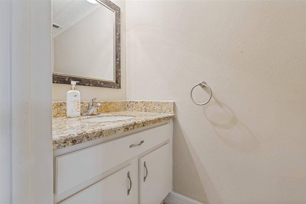 9400 Doliver Drive, #59, Houston, TX 77063 Vanity with a granite countertop, undermount sink, and chrome faucet