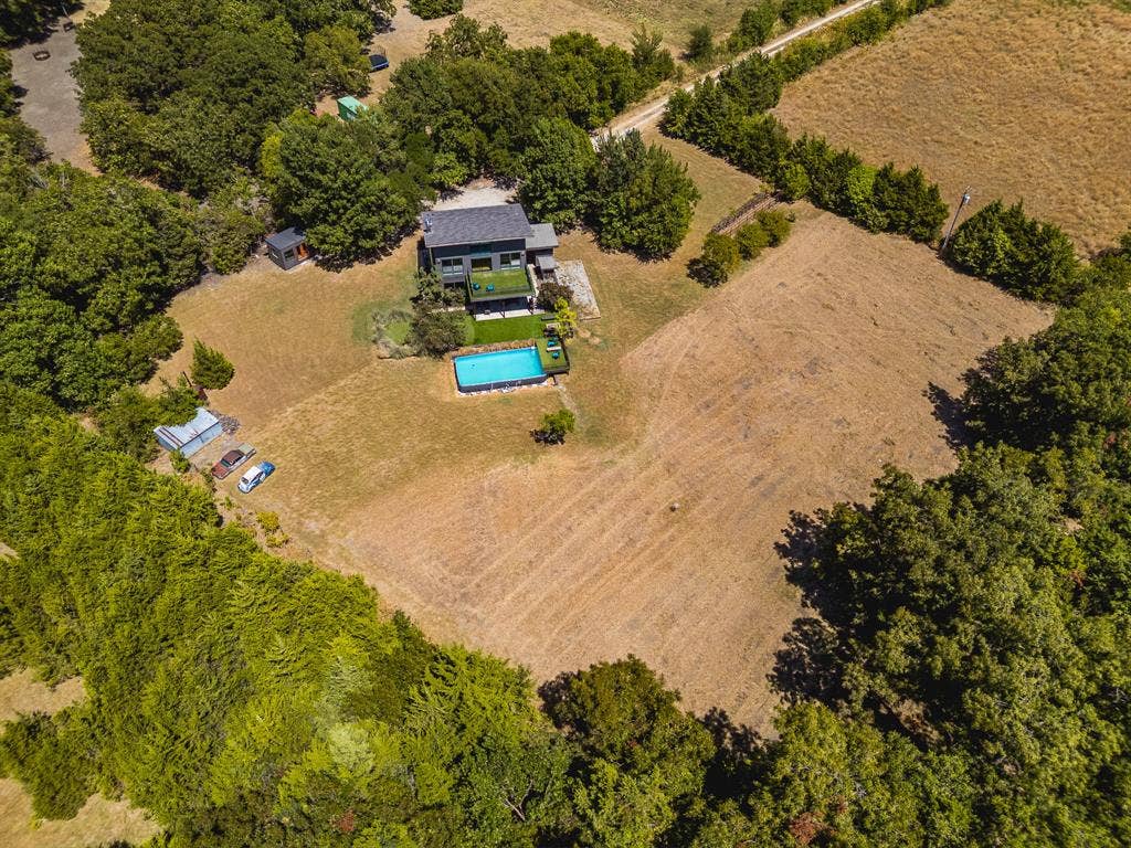 6448 County Road 437, Princeton, TX 75407 Property featuring a contemporary exterior, an in-ground swimming pool, and extensive surrounding land