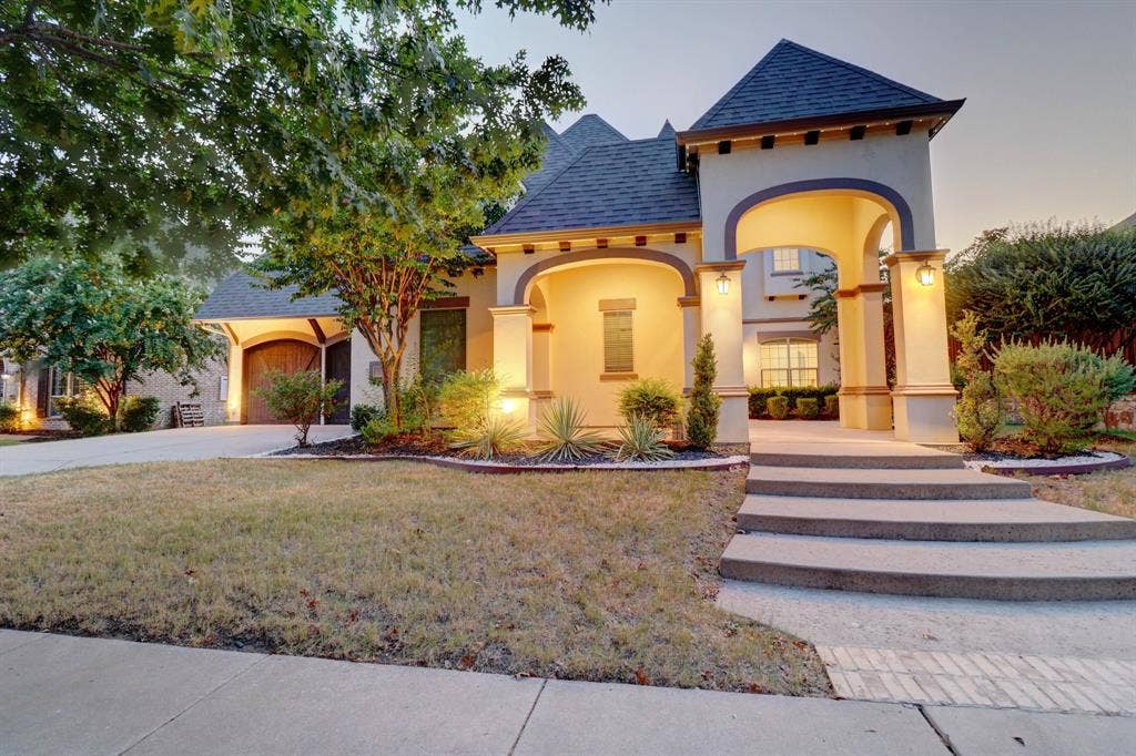 11559 Ashley Lane, Frisco, TX 75035 Stucco exterior with arched entry, multi-level concrete steps, and a side-entry garage with a wood-finish door
