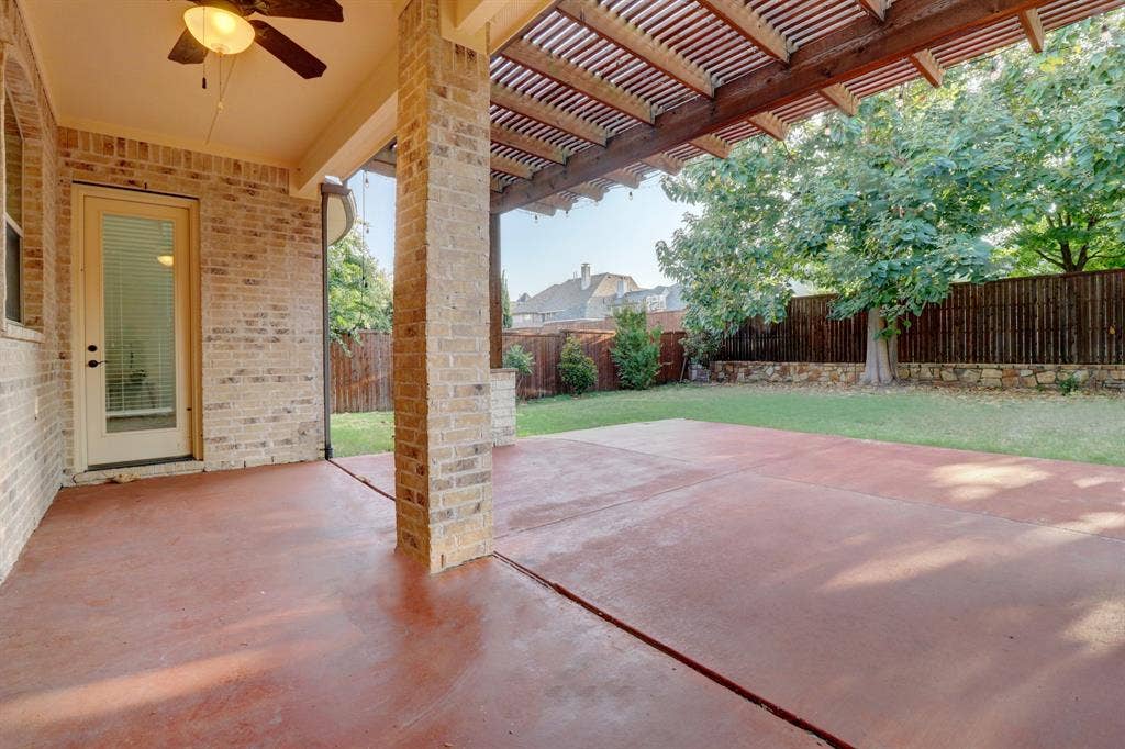 11559 Ashley Lane, Frisco, TX 75035 Expansive covered patio with wood-finish ceiling and ceiling fan, anchored by substantial brick columns