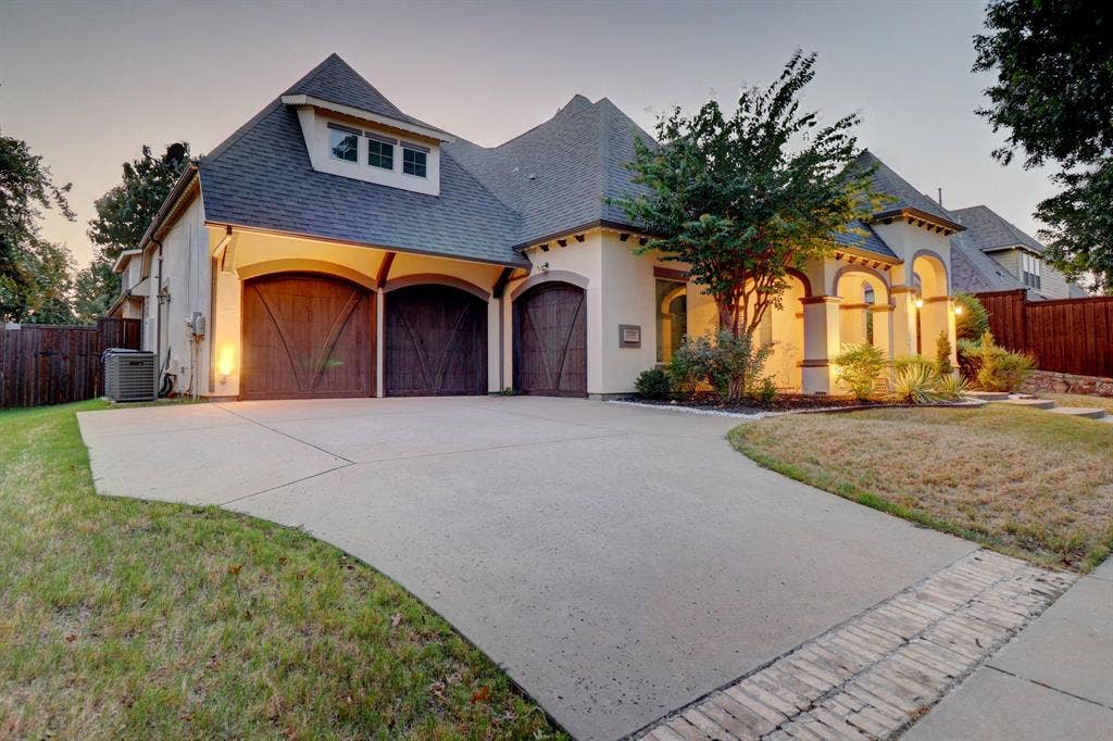 11559 Ashley Lane, Frisco, TX 75035 Stucco exterior with arched entryways and wooden garage doors