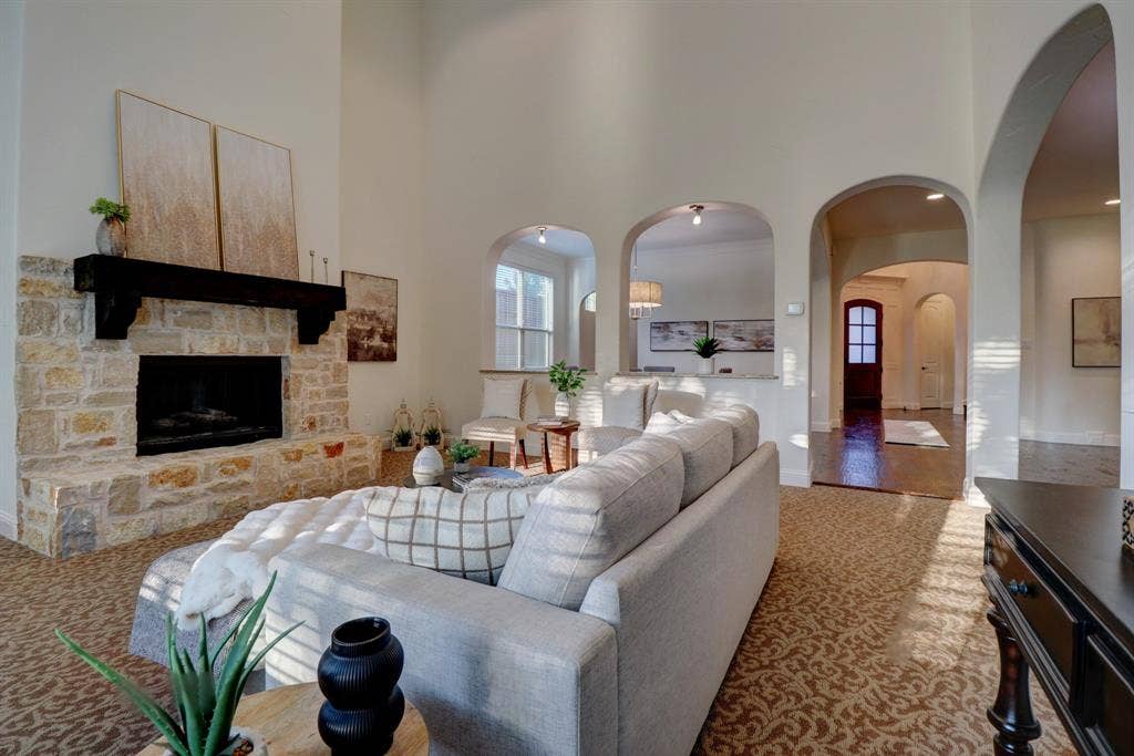 11559 Ashley Lane, Frisco, TX 75035 Stone fireplace with a dark wood mantel and high ceilings