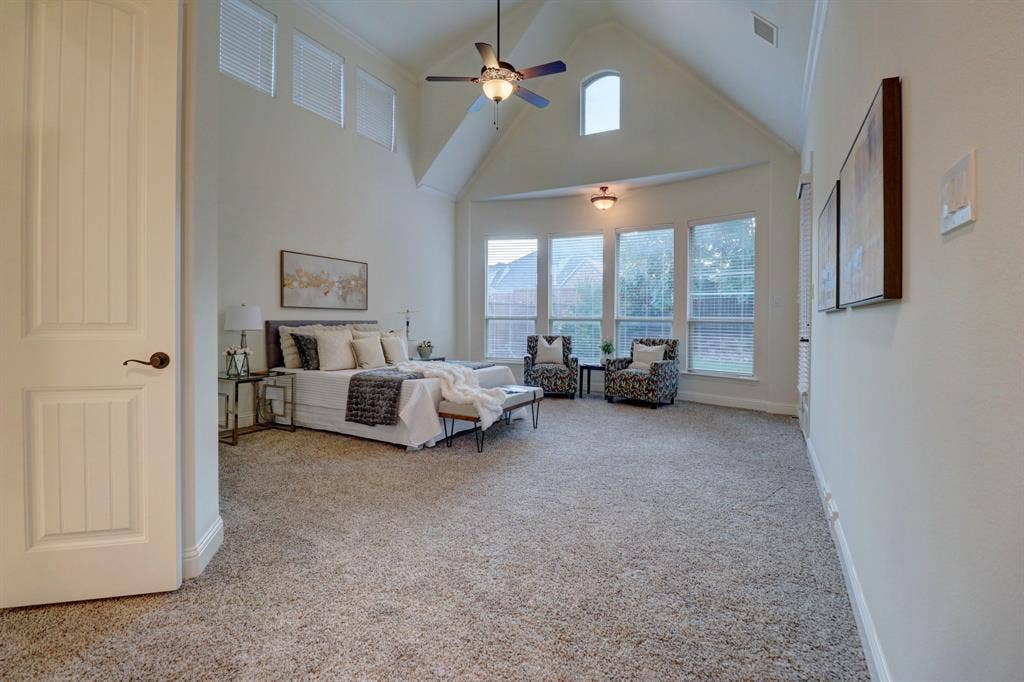 11559 Ashley Lane, Frisco, TX 75035 Vaulted ceiling with ceiling fan, arched transom window, recessed bay window area, and neutral carpet flooring