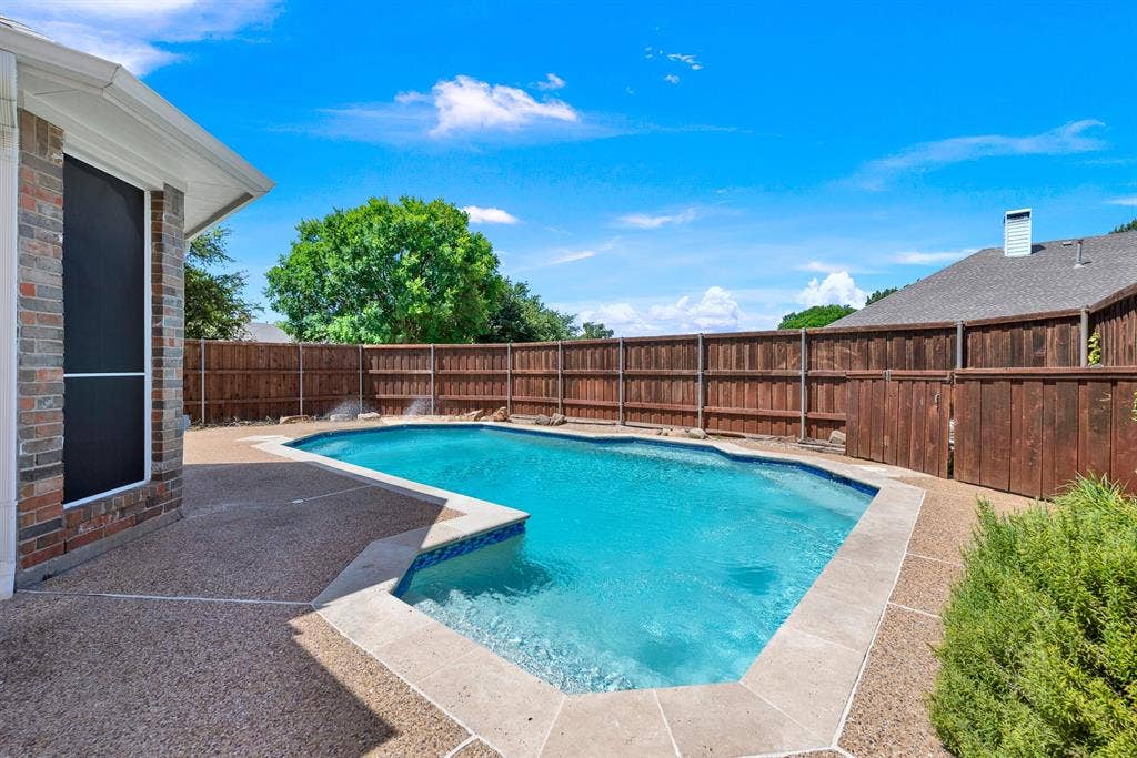 3217 Royal Melbourne Drive, Plano, TX 75093 A sparkling blue pool bordered by coping and cool-tone patio decking forms a private backyard oasis enclosed by high wooden privacy fencing. It offers a refreshing escape where you can cool off during warm summer afternoons or lounge poolside in complete privacy.