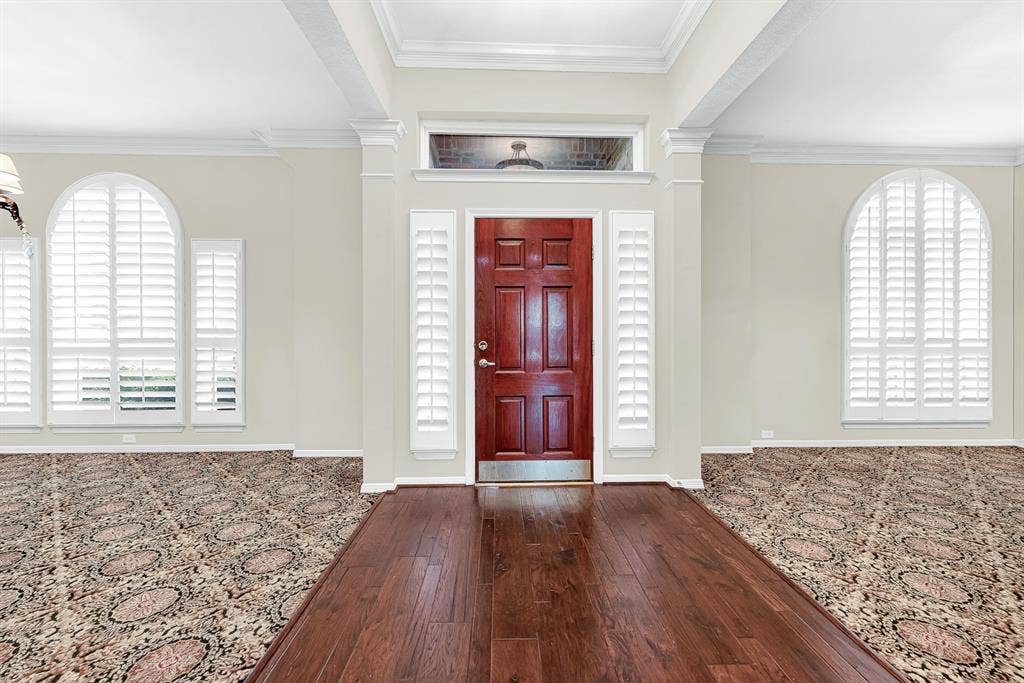 3217 Royal Melbourne Drive, Plano, TX 75093 Rich hardwood flooring creates a welcoming grand entrance, flanked by arched windows with plantation shutters and balanced openings to formal spaces. You will love greeting your guests in this bright foyer that sets a warm, sophisticated tone the second anyone walks through the front door.