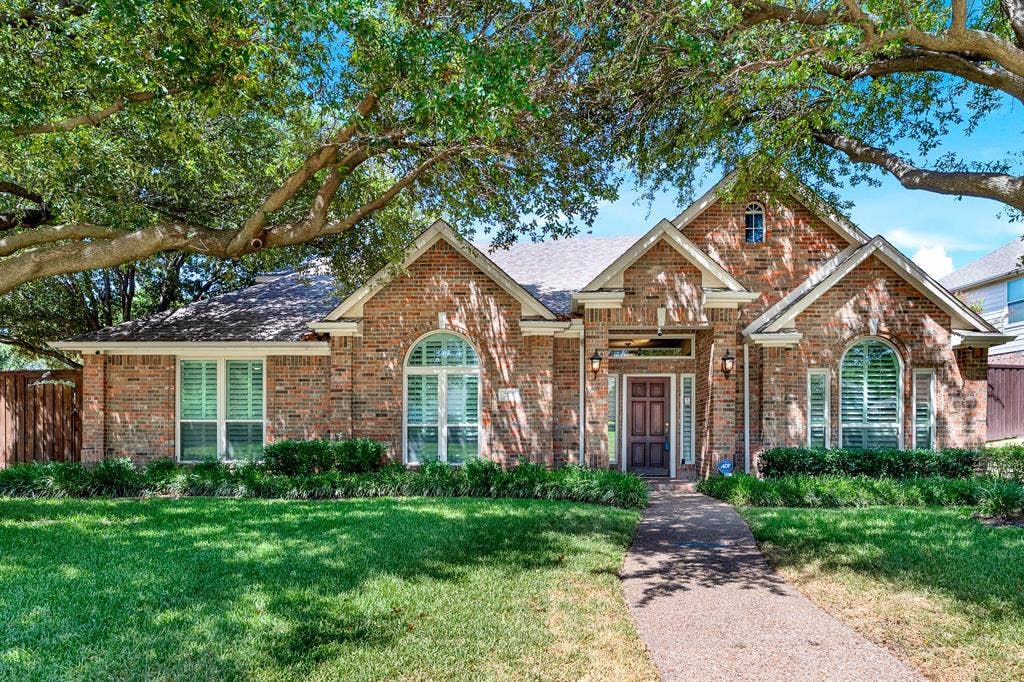 3217 Royal Melbourne Drive, Plano, TX 75093 Welcome to 3217 Royal Melbourne in the prestigious neighborhood of The Hills at Prestonwood near the Prestonwood Golf Club! A classic brick elevation is framed by mature canopy trees, neat landscaping, and a central walkway leading to a covered front entry. You will love coming home to unmatched curb appeal that instantly welcomes family and friends with warm, timeless charm.