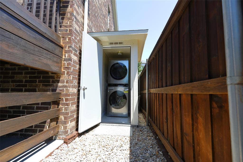3707 Plum Vista Place, Arlington, TX 76005 Enclosed laundry area featuring a stacked washer and dryer unit, set on a gravel pathway