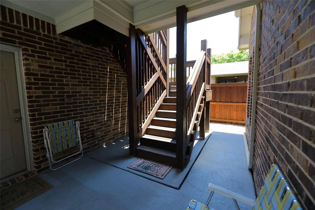 3707 Plum Vista Place, Arlington, TX 76005 Covered outdoor walkway featuring a wooden staircase, brick wall, and concrete flooring