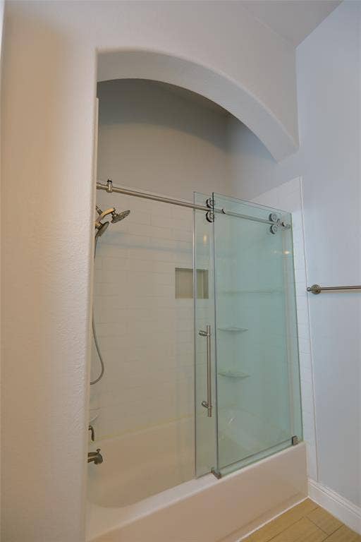 3707 Plum Vista Place, Arlington, TX 76005 Bathtub with white subway tile surround, recessed shelf, and built-in shelving