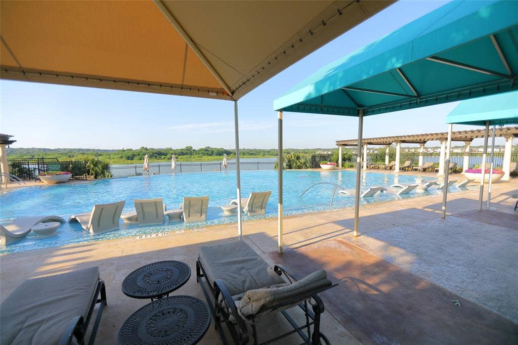 3707 Plum Vista Place, Arlington, TX 76005 Expansive infinity-edge pool surrounded by a concrete deck with multiple shade structures