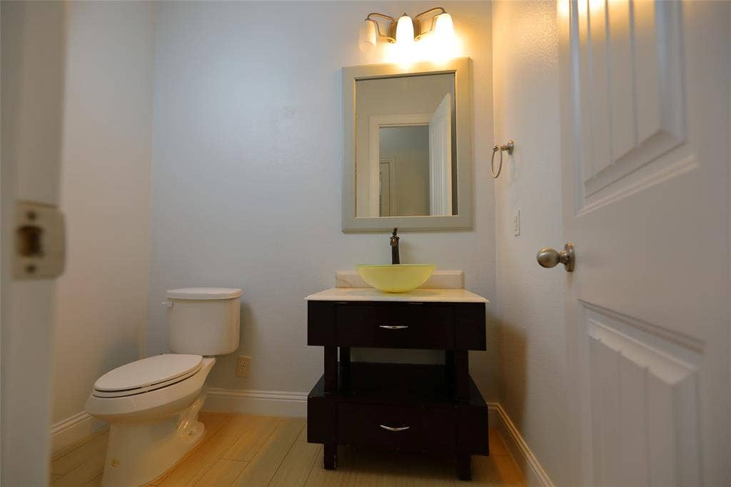 3707 Plum Vista Place, Arlington, TX 76005 Modern vanity with an amber vessel sink, dark wood-finish cabinetry, and a light-toned countertop