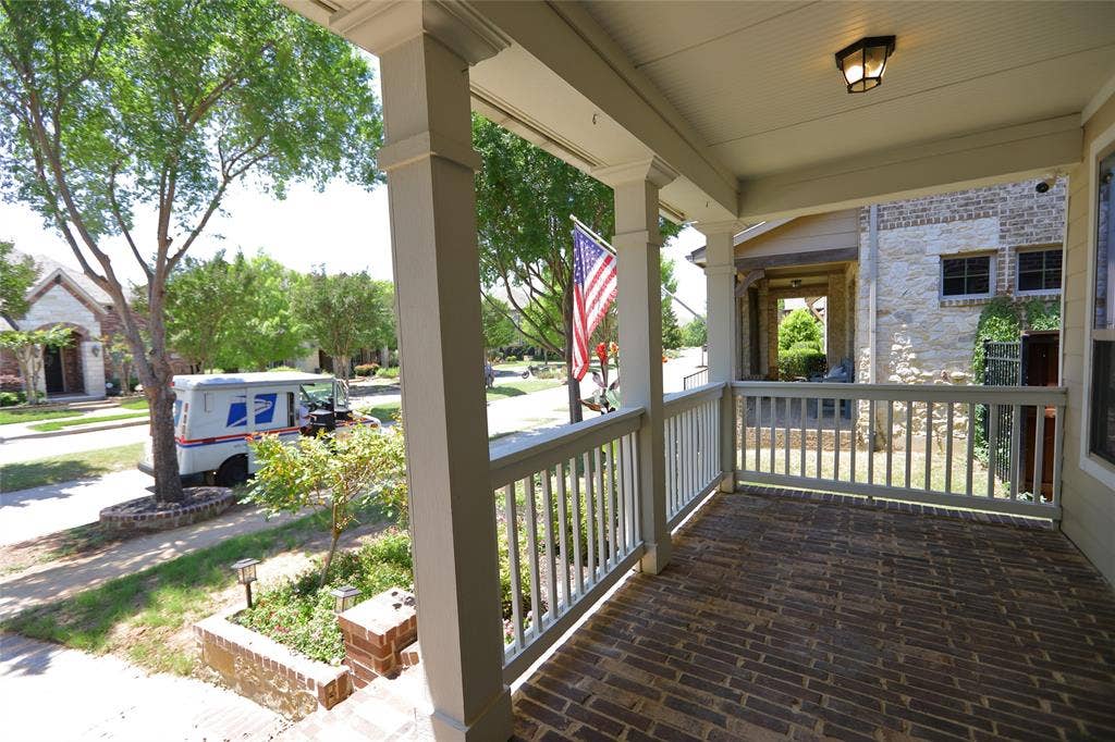 3707 Plum Vista Place, Arlington, TX 76005 Brick-paved front porch featuring white painted railings, substantial support columns, a beadboard ceiling, and a mounted outdoor light fixture