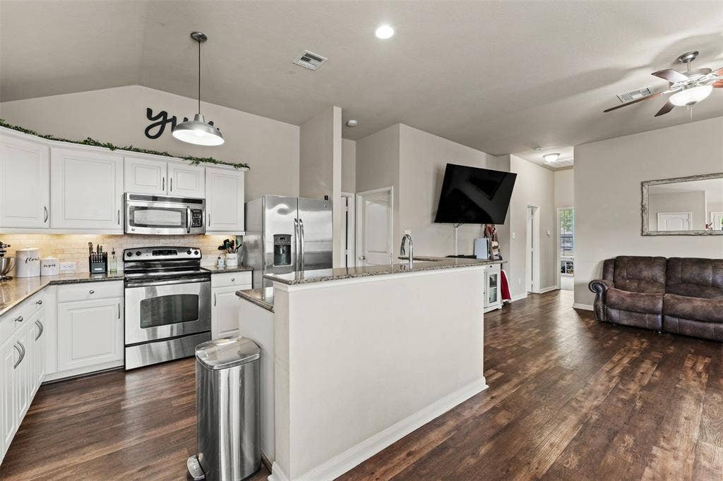 10313 Condor Loop, Waco, TX 76708 Kitchen featuring white cabinetry, stainless steel appliances, granite countertops, and wood-finish flooring