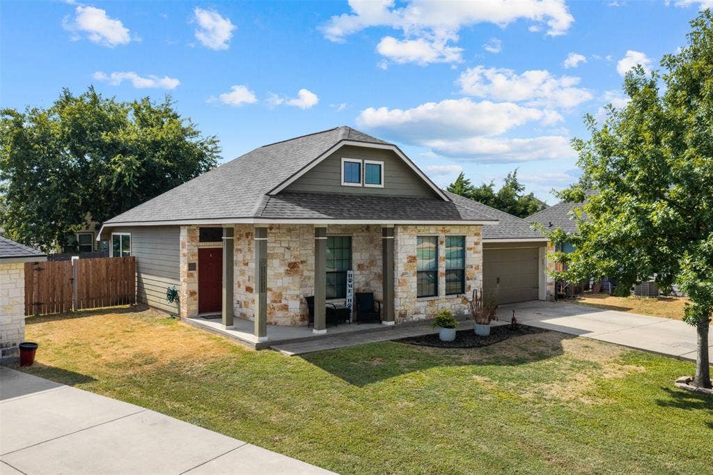 10313 Condor Loop, Waco, TX 76708 Stone and siding exterior with a covered porch, a two-car garage, and a concrete driveway