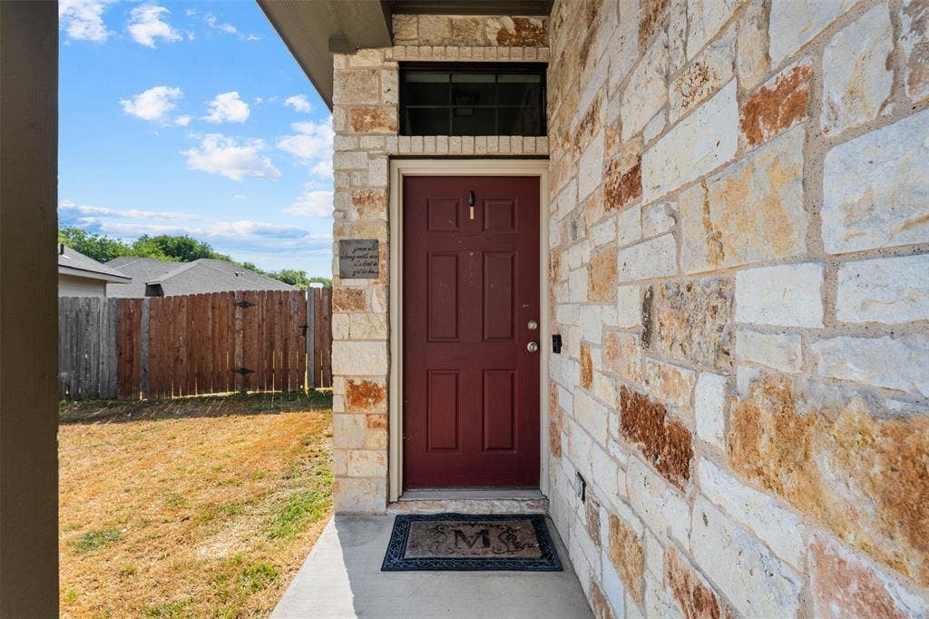 10313 Condor Loop, Waco, TX 76708 Stone veneer exterior, solid wood entry door, and concrete porch