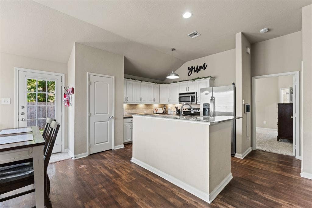 10313 Condor Loop, Waco, TX 76708 Kitchen featuring white cabinetry, stainless steel appliances, a kitchen island with a stone-finish countertop, wood-finish flooring, and recessed lighting