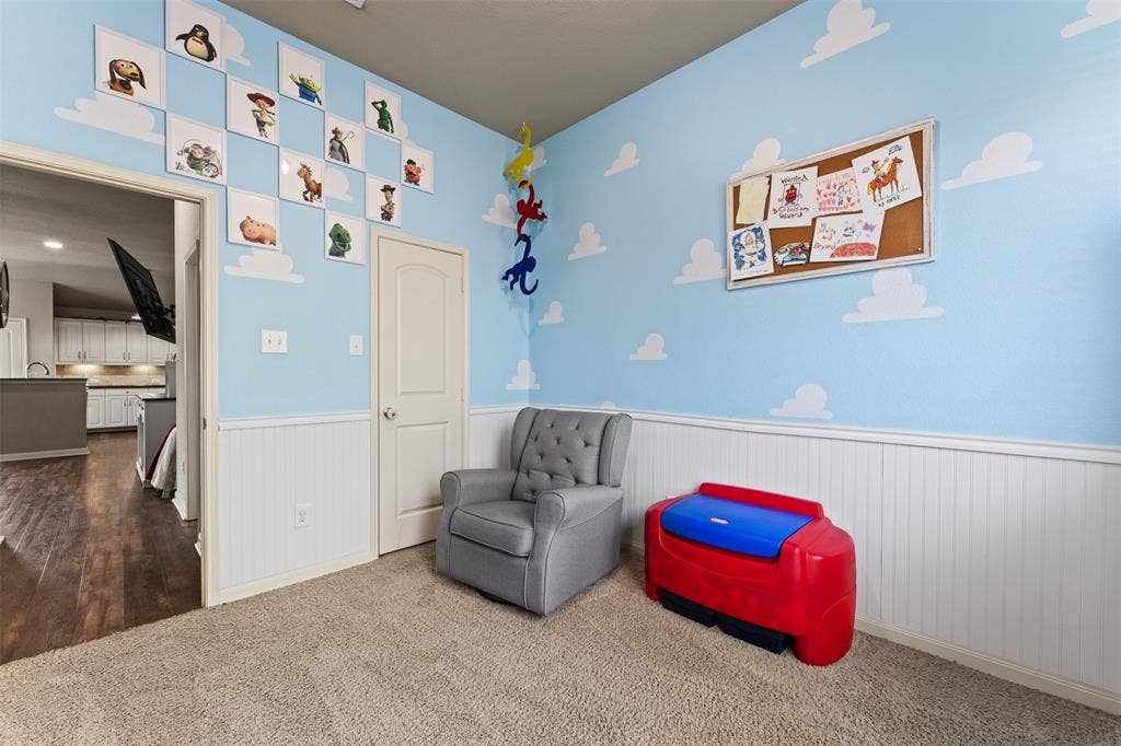 10313 Condor Loop, Waco, TX 76708 Carpeted room featuring white wainscoting and a solid core door